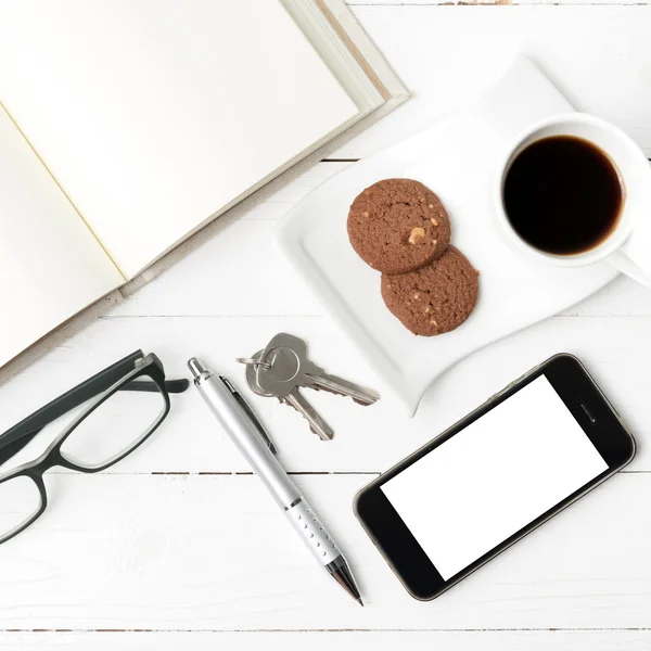 Xícara de café com biscoito, telefone, caderno aberto, chave e óculos — Fotografia de Stock