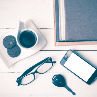 Kahve Kupası ile tanımlama bilgisi, telefon, araba anahtarı, gözlük ve kitap yığını