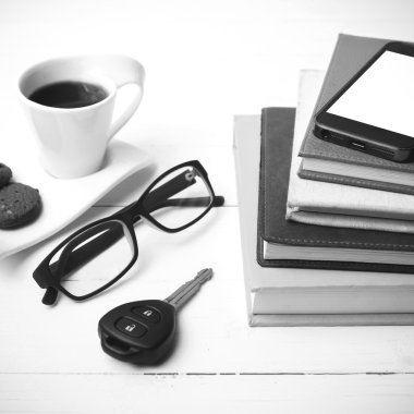 Kahve Kupası ile tanımlama bilgisi, telefon, araba anahtarı, gözlük ve kitap yığını