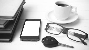 kahve fincanı ile telefon, araba anahtarı, gözlük ve kitap blac yığını