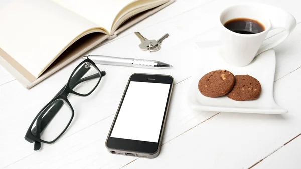 Taza de café con galletas, teléfono, cuaderno abierto, llave y anteojos — Foto de Stock