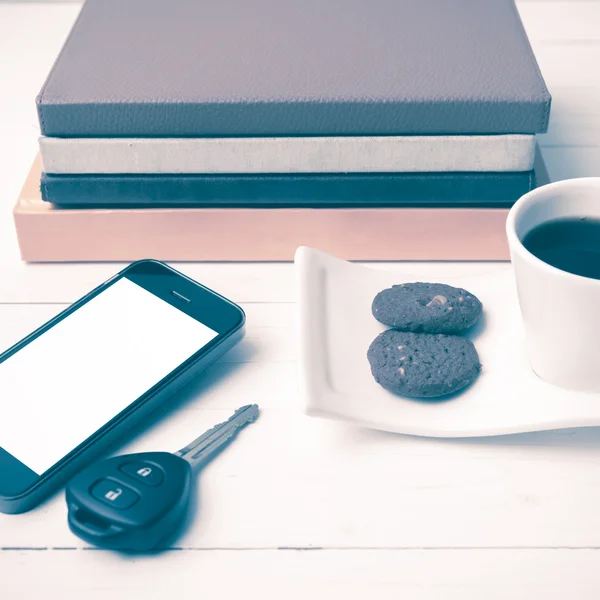 Xícara de café com biscoito, telefone, chave do carro e pilha de livro vintage st — Fotografia de Stock