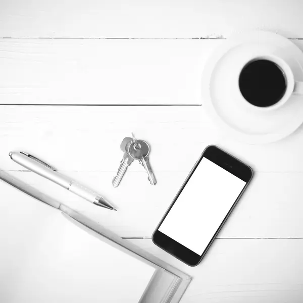 Xícara de café com telefone, chave e col aberto caderno preto e branco — Fotografia de Stock