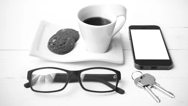 Tasse à café avec cookie, téléphone, lunettes et clé noir et blanc — Photo