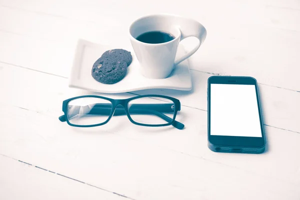 Tazza di caffè con biscotto, telefono e occhiali stile vintage — Foto Stock