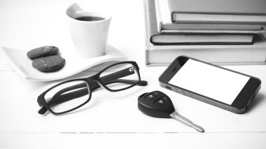 Kahve Kupası ile tanımlama bilgisi, telefon, araba anahtarı, gözlük ve kitap yığını