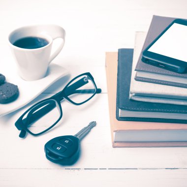 Kahve Kupası ile tanımlama bilgisi, telefon, araba anahtarı, gözlük ve kitap yığını