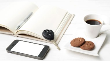 tanımlama bilgisi, telefon, açık defter ve araba anahtarı ile kahve fincanı