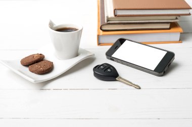 Kahve Kupası ile tanımlama bilgisi, telefon, araba anahtarı ve kitap yığını