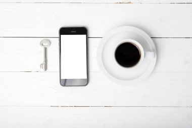 kahve fincanı ile telefon ve anahtar