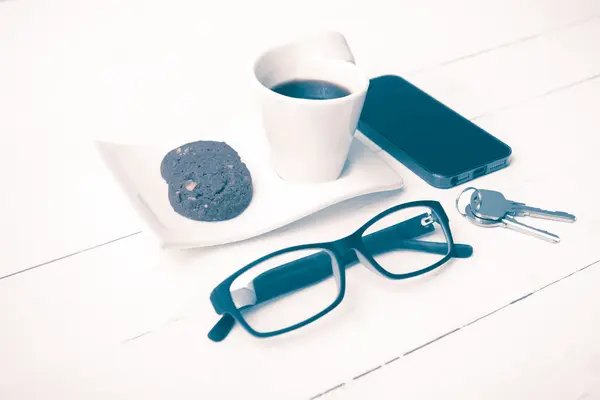 Koffiekopje met cookie, telefoon, brillen en sleutel vintage stijl — Stockfoto