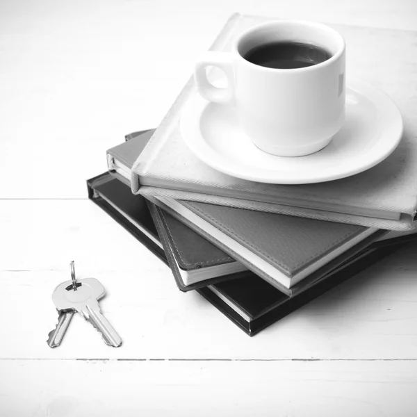 Tazza di caffè, chiave e pila di libro colore bianco e nero — Foto Stock