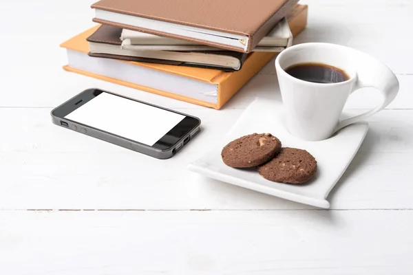 Taza de café con galletas, teléfono y pila de libros — Foto de Stock