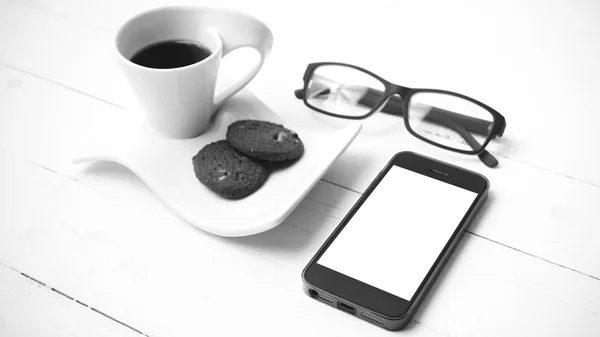Xícara de café com biscoito, telefone e óculos colo preto e branco — Fotografia de Stock