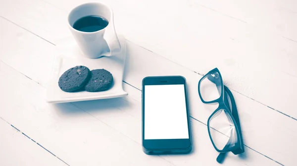 Xícara de café com biscoito, telefone e óculos estilo vintage — Fotografia de Stock