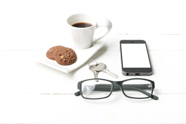 Taza de café con galletas, teléfono, anteojos y llave — Foto de Stock