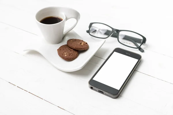 Tazza di caffè con biscotto, telefono e occhiali — Foto Stock