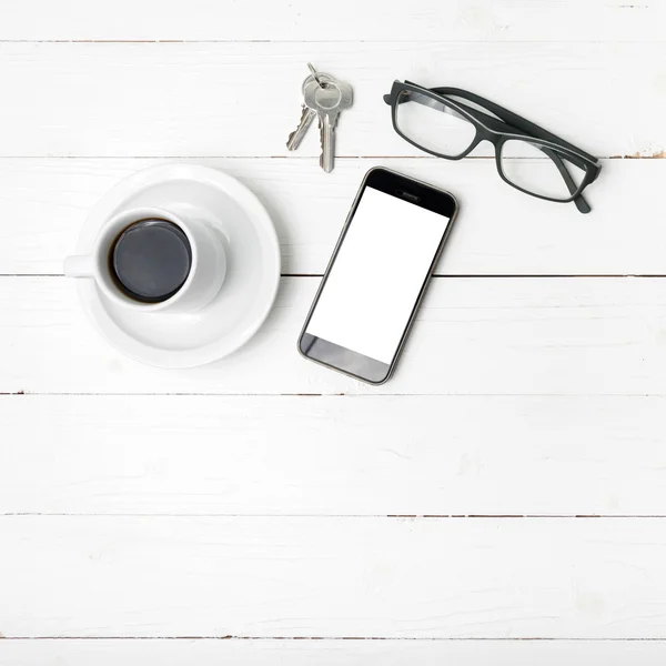 Чашка кави з телефоном, окулярами та ключем — стокове фото