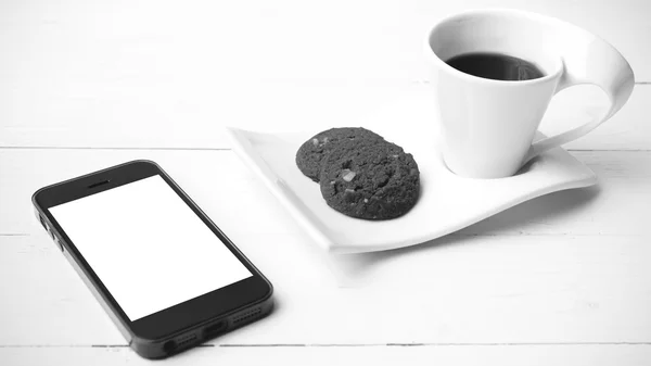 Coffee cup with cookie and phone black and white color — Stock Photo, Image