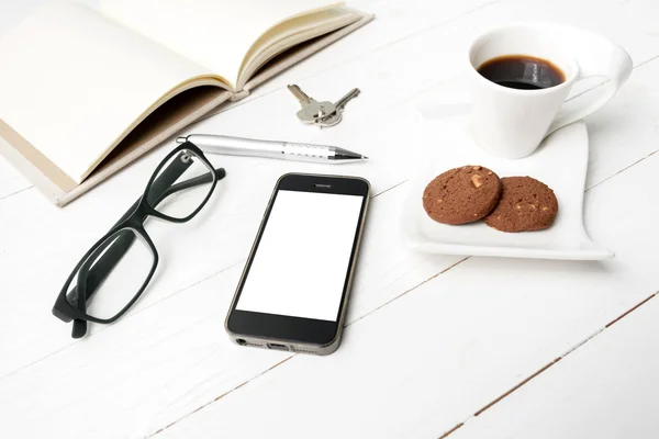 Xícara de café com biscoito, telefone, caderno aberto, chave e óculos — Fotografia de Stock