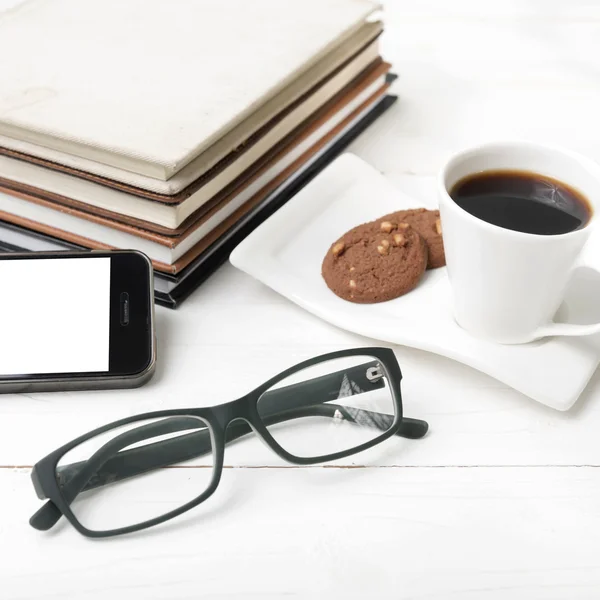 Φλιτζάνι καφέ με cookie, τηλέφωνο, στοίβα βιβλίων και γυαλιά — Φωτογραφία Αρχείου