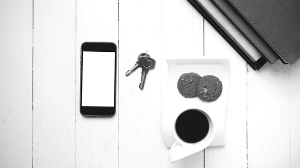 Taza de café con galletas, teléfono, pila de libro y llave negro y whi —  Fotos de Stock