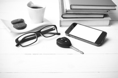 Kahve Kupası ile tanımlama bilgisi, telefon, araba anahtarı, gözlük ve kitap yığını