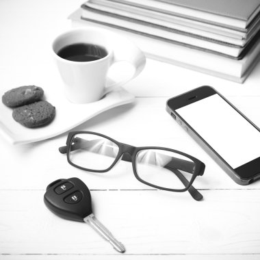 Kahve Kupası ile tanımlama bilgisi, telefon, araba anahtarı, gözlük ve kitap yığını