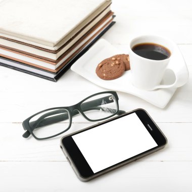 tanımlama bilgisi, telefon, kitap ve gözlük yığını ile kahve fincanı