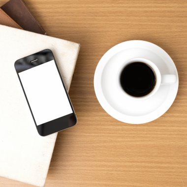 kahve fincanı ve telefon ve kitap yığını