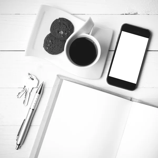 Xícara de café com biscoito, telefone, caderno e chave co preto e branco — Fotografia de Stock