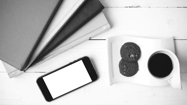 Taza de café con galletas, teléfono y pila de libro blanco y negro co — Foto de Stock