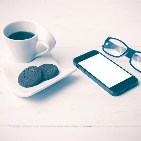 Coffee cup with cookie,phone and eyeglasses vintage style — Stock Photo, Image