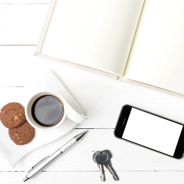 Чашка кави з печивом, телефоном, зошитом та ключем — стокове фото