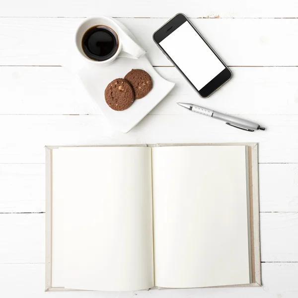Xícara de café com biscoito, telefone com caderno e caneta — Fotografia de Stock