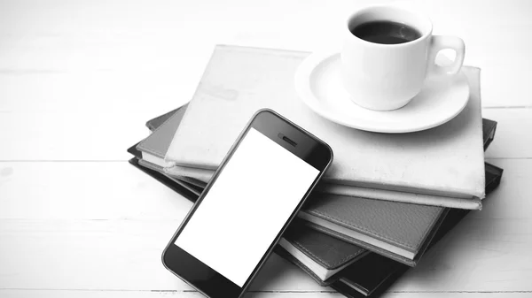 coffee cup with phone and stack of book black and white color