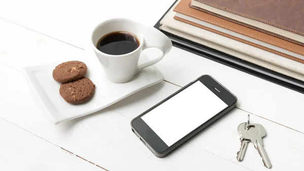 Xícara de café com biscoito, telefone de pilha de livro e chave — Fotografia de Stock