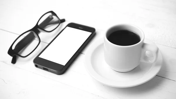 Tasse à café avec téléphone et lunettes de vue couleur noir et blanc — Photo