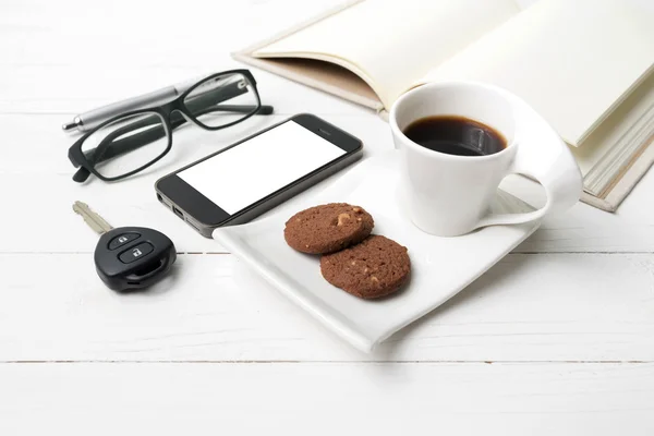 Taza de café con galletas, teléfono, cuaderno abierto, llave del coche y anteojos — Foto de Stock