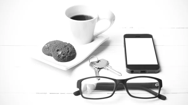 Csésze kávé, süti, a telefon, a szemüveg és a kulcs fekete-fehér — Stock Fotó