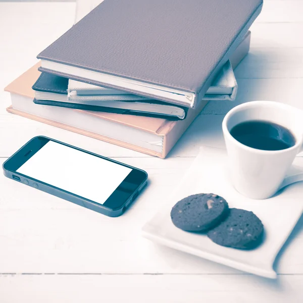 Xícara de café com biscoito, telefone e pilha de estilo vintage de livro — Fotografia de Stock