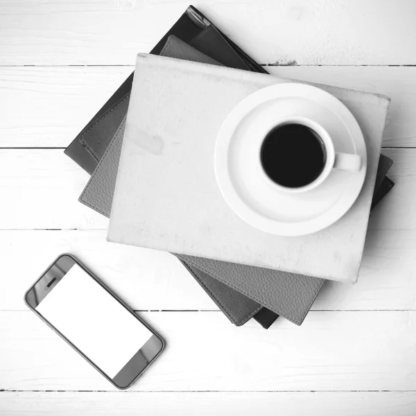Чашка кави з телефоном і стопка книги чорно-білого кольору — стокове фото