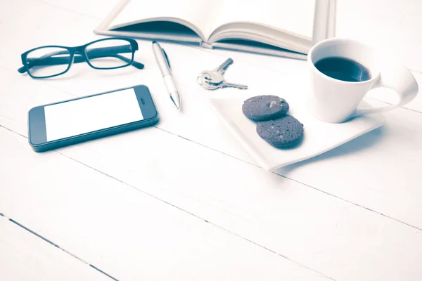 Xícara de café com biscoito, telefone, caderno aberto, chave e óculos vi — Fotografia de Stock