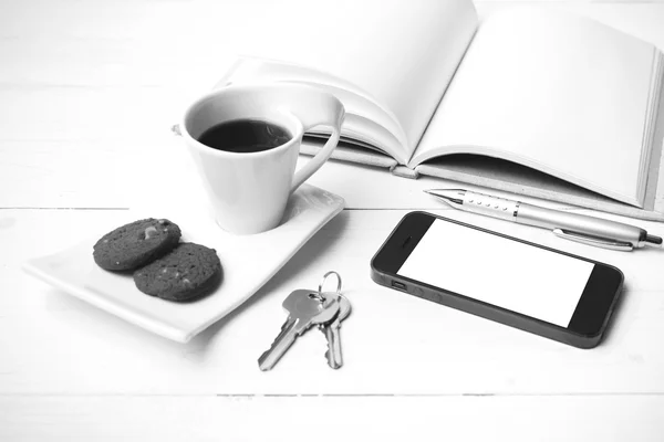 Xícara de café com biscoito, telefone, caderno e chave co preto e branco — Fotografia de Stock