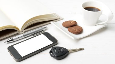 tanımlama bilgisi, telefon, açık defter ve araba anahtarı ile kahve fincanı