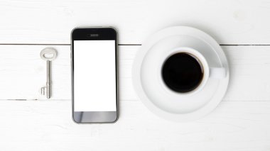 kahve fincanı ile telefon ve anahtar