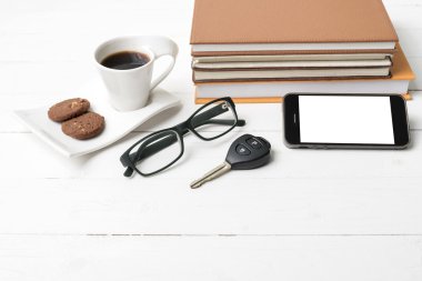 Kahve Kupası ile tanımlama bilgisi, telefon, araba anahtarı, gözlük ve kitap yığını