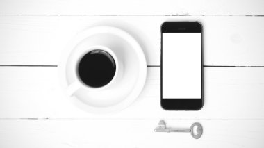 kahve fincanı ile telefon ve anahtar siyah ve beyaz renk