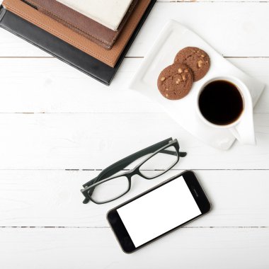 tanımlama bilgisi, telefon, kitap ve gözlük yığını ile kahve fincanı
