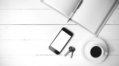 kahve fincanı ile telefon, anahtar ve açık defter siyah beyaz col